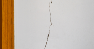 A mobile home with visible foundation damage, including cracks in the walls and uneven floors, indicating the need for foundation repair.