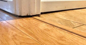 Uneven wood floor in a mobile home showing sloping and gaps caused by mobile home leveling issues